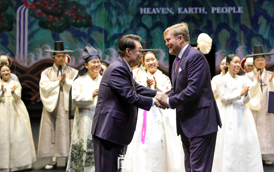 Korean President Yoon Suk Yeol, left, and Dutch King Willem-Alexander shake hands at a bilateral cultural event showcasing traditional Korean performances at AFAS Live, a concert hall in Amsterdam, on Wednesday. This marks the first such cultural event, arranged in return for the invitation for a five-day state visit to the Netherlands by the king. Culture Minister Yoo In-chon, an actor, read a congratulatory message wishing for the development, prosperity and friendship between the two countries, commemorating the first state visit of a Korean president since the establishment of diplomatic relations in the Netherlands in 1961. [JOINT PRESS CORPS]