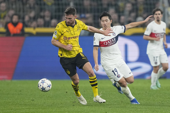 PSG's Lee Kang-in, right, in action with Dortmund's Salih Ozcan, during a UEFA Champions League Group F game at the Westfalen Stadium in Dortmund, Germany on Wednesday.  [AFP/YONHAP]