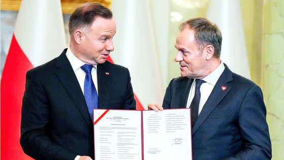 Polish President Andrzej Duda, left, and newly appointed Polish Prime Minister Donald Tusk attend the cabinet swearing-in ceremony at the Presidential Palace in Warsaw on Wednesday. [REUTERS/YONHAP]