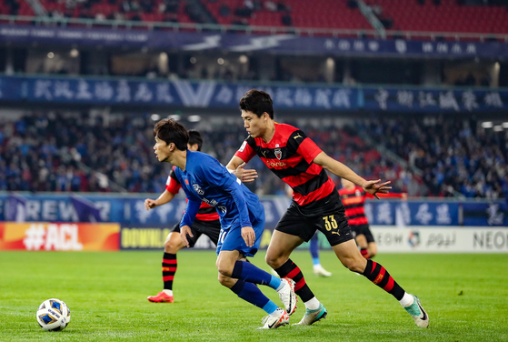 The Pohang Steelers' Lee Ho-jae, right, in action during an AFC Champions League match against Wuhan Three Towns at Wuhan Sports Center Stadium in Wuhan, China on Dec. 6. [AFC]