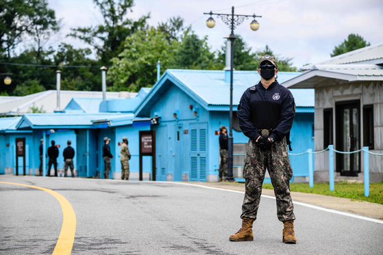A South Korean soldier, right, and UN Command soldiers stand guard near the military demarcation line separating the two Koreas at the Joint Security Area of the Demilitarized Zone in the truce village of Panmunjom on Oct. 4, 2022. [AFP/YONHAP]