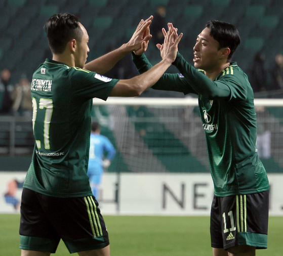 Jeonbuk Hyundai Motors' Lee Dong-jun, right, celebrates scoring a goal with Moon Seon-min during an AFC Champions League match against Bangkok United at Jeonju World Cup Stadium in Jeonju, North Jeolla on Wednesday. [YONHAP]