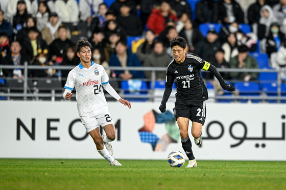 Ulsan Hyundai's Lee Chung-yong, right, dribbles the ball during an AFC Champions League match against Kawasaki Frontale at Ulsan Munsu Football Stadium in Ulsan on Wednesday. [AFC]