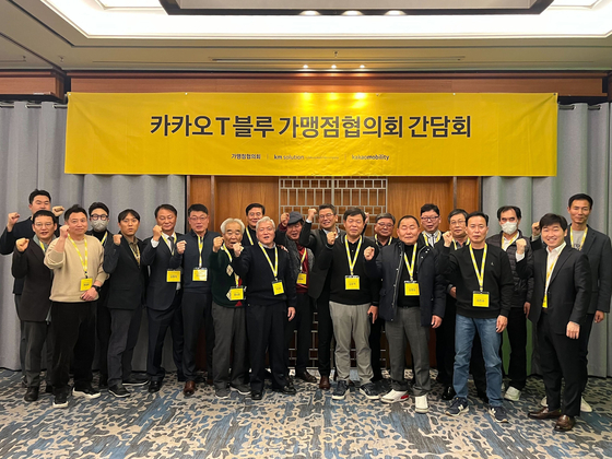 Kakao Mobility executives and representatives from taxi unions pose for the photo after agreeing to the company's lower commission rate at a meeting on Wednesday. [KAKAO MOBILITY]