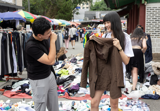 A young tourist couple enjoys their visit at Dongmyo Flea Market. [CHOI GI-UNG]