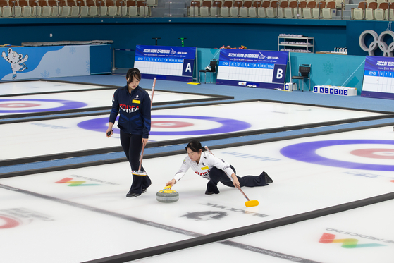 Curler Jang Yu-bin, left, trains with Lee So-won at Gangnueng Curling Centre in Gangnueng, Gangwon on Tuesday. [GANGWON YOUTH OLYMPICS ORGANIZING COMMITTEE]