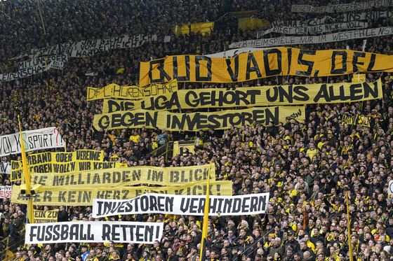 Fans hold up banners protesting against investors in German football during the Bundesliga match between Borussia Dortmund and Union Berlin in Dortmund, Germany on April 8. [AP/YONHAP]