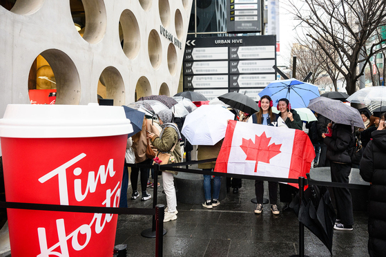 Rain didn't deter the crowd that lined up ahead of the grand opening of Tim Hortons' first Korean store in Gangnam District, southern Seoul, on Thursday. [TIM HORTONS KOREA]