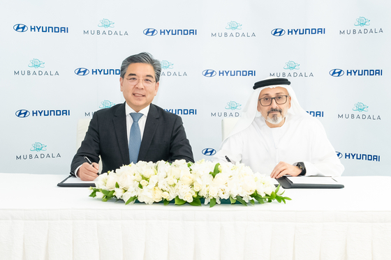 Hyundai Motor CEO Chang Jae-hoon, left, and Waleed Al Mokarrab Al Muhairi, deputy group CEO of the United Arab Emirates' sovereign investor Mubadala Investment Company, take a photo during a memorandum of understanding (MOU) signing ceremony on Friday in Abu Dhabi. Hyundai Motor said on Sunday that it signed an MOU with Mubadala Investment Company to collaborate on eco-friendly mobility and energy businesses. [HYUNDAI MOTOR]