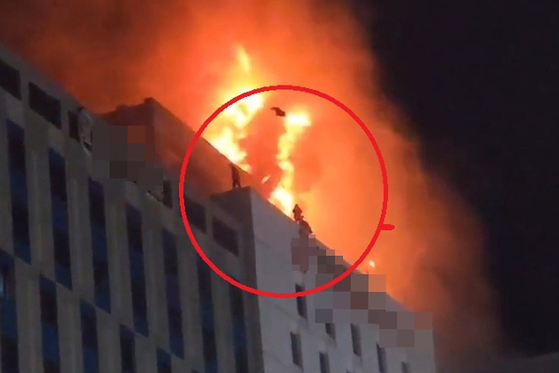 People jump from the Grand Palace Hotel's rooftop to escape from fire by landing on the rooftop of a nearby building. [YONHAP] 