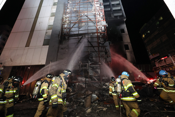 Firefighters extinguish a fire that broke out at a hotel in Incheon on Sunday. [YONHAP]