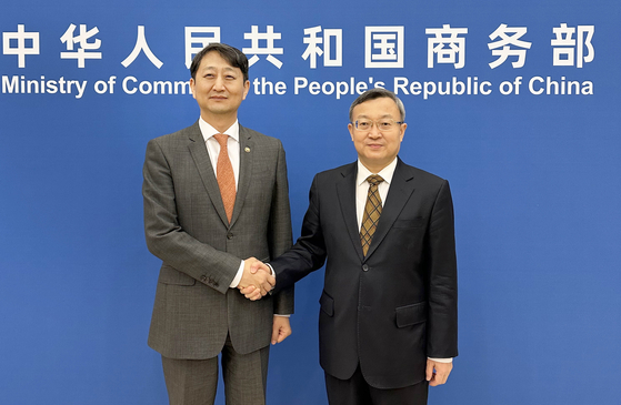 Ahn Duk-geun, left, industry minister nominee who then served as the trade minister, poses for a photo with his Chinese counterpart, Wang Shouwen, prior to their talks at the Chinese commerce ministry in Beijing on Dec. 4. [MINISTRY OF TRADE, INDUSTRY AND ENERGY]