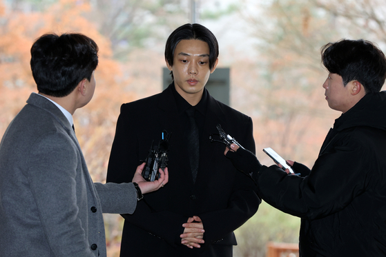 Actor Yoo Ah-in answers questions from reporters before his trial over drug-related charges at the Seoul Central District Court in Seocho District, southern Seoul, on Dec. 12. [YONHAP]
