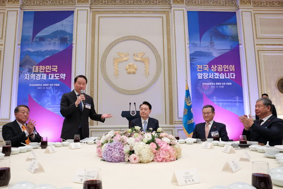 President Yoon Suk Yeol, center, listens as SK Group Chairman Chey Tae-won, second from left, head of the Korea Chamber of Commerce and Industry (KCCI), speaks during a luncheon meeting with heads of local chambers of commerce and industry at the Blue House in central Seoul on Tuesday. During this meeting, Yoon stressed the government’s efforts toward a sound fiscal policy at a time of complex global crises and promised to create a good environment for businesses to expand in the global market. [PRESIDENTIAL OFFICE]