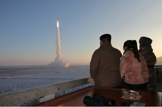 North Korean leader Kim Jong-un, left, accompanied by his daughter Ju-ae, center, watches the launch of a Hwasong-18 solid-fuel intercontinental ballistic missile (ICBM) in a drill at an undisclosed location in a photo released by the Rodong Sinmun Tuesday. [NEWS1]