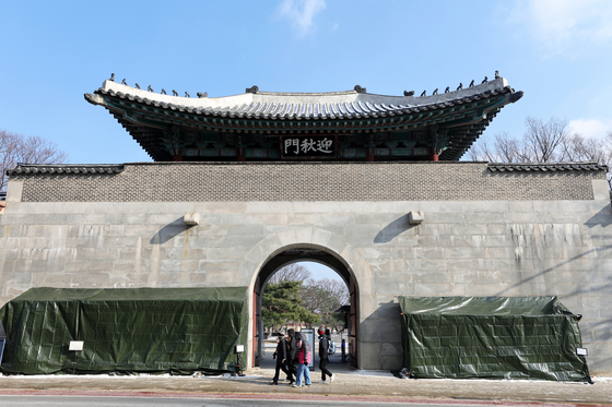 Vandalized part of Yeongchumun, the western gate of Gyeongbok Palace, is covered up for repairs on Wednesday. [JOONGANG PHOTO]