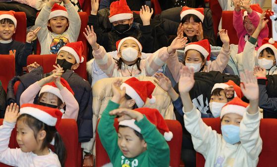 Children at neighborhood-based afterschool childcare facilities enjoy a Christmas party titled “Dreaming at Christmas,” held at Yongsan Kkumnamu Youth Town in Yongsan District, central Seoul, on Wednesday. The childcare facilities are located within a 10-minute walking distance from each elementary school and are open to all elementary school students who need care after class. [NEWS1]
