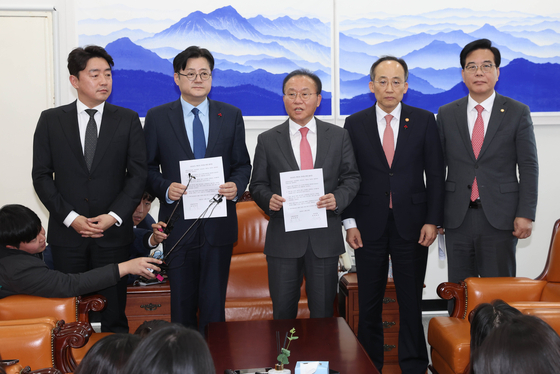 Leaders of the governing and opposition parties and Finance Minister Choo Kyung-ho, fourth from left, pose for a photo on Wednesday after agreeing on a budget proposal at the National Assembly in Yeouido, western Seoul. [YONHAP]