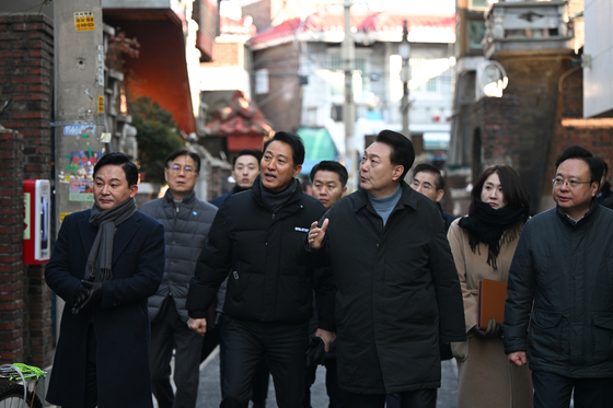 President Yoon Suk Yeol, center right, and Land Minister Won Hee-ryong, left, listen to Seoul Mayor Oh Se-hoon, center left, during a visit to the city government’s “Moa Town” urban regeneration project in Jungnang District, eastern Seoul, on Thursday. [PRESIDENTIAL OFFICE]