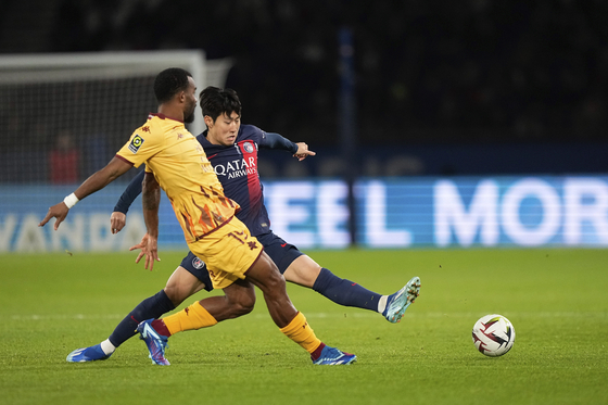 Paris Saint-Germain's Lee Kang-in challenges for the ball with FC Metz's Habib Maiga, during a Ligue 1 match at Parc des Princes in Paris on Wednesday. [AP/YONHAP]