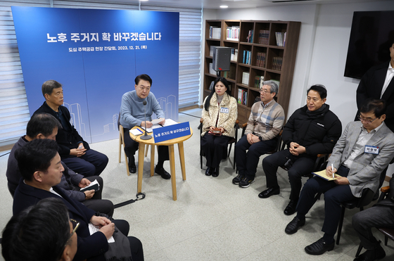 President Yoon Suk Yeol, center, speaks with residents of the neighborhood during a visit to the city government’s “Moa Town” urban regeneration project site in Jungnang District, eastern Seoul, on Thursday. [JOINT PRESS CORPS]