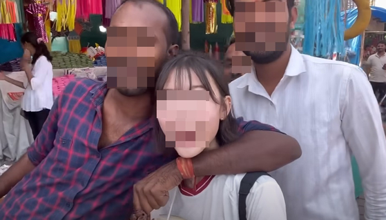 A man can be seen inappropriately hugging YouTuber Kelly in her video. [SCREEN CAPTURE]