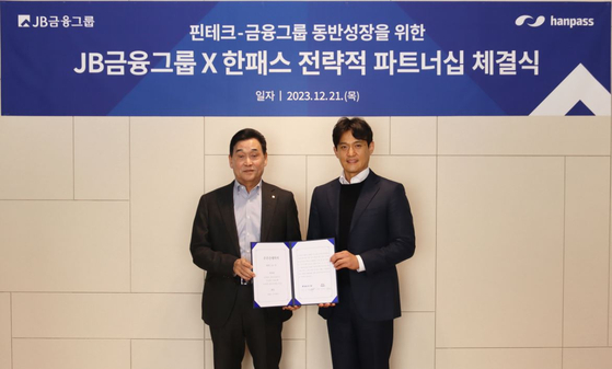 JB Financial Group Chairman Kim Ki-hong, left, and Hanpass CEO Kim Kyung-hoon. JB will acquire 15 percent of Hanpass, a mobile overseas remittance service provider, as part of its plans to expand services to foreigners. [JB FINANCIAL GROUP]