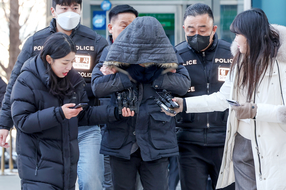 A man in his 40s, who kidnapped an elementary student that lived on the same apartment building for ransom, being escorted by the police to the Seoul Nothern District Court in Donbong District, Seoul on Thursday. [NEWS1]
