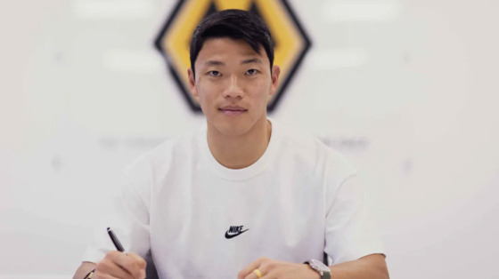 Hwang Hee-chan poses while signing a new contract with Wolverhampton Wanderers in a photo shared by the club on Thursday.  [WOLVERHAMPTON WANDERERS]