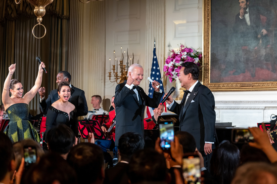 U.S. President Joe Biden, center, and Broadway stars, left, react as Korean President Yoon Suk Yeol, right, sings ″American Pie″ by Don McLean during a state dinner at the White House in Washington on April 26. [JOINT PRESS CORPS]
