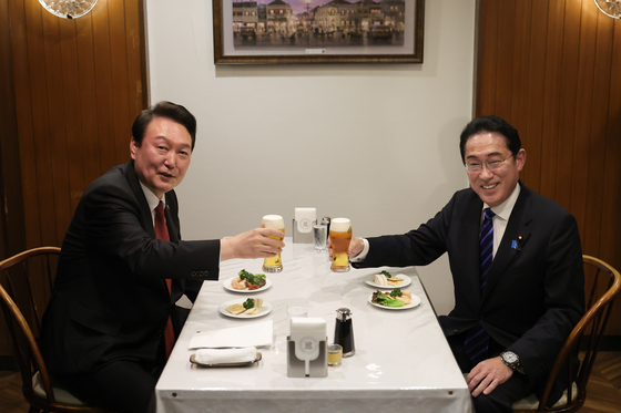 Korean President Yoon Suk Yeol, left, and Japanese Prime Minister Fumio Kishida raise glasses of beer at a restaurant in Ginza, Tokyo, after their bilateral summit on March 16. [JOINT PRESS CORPS]