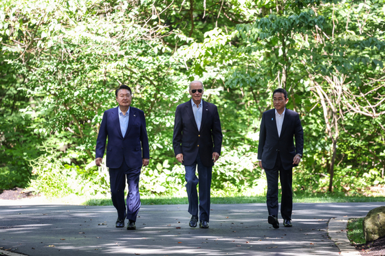 From left, Korean President Yoon Suk Yeol, U.S. President Joe Biden and Japanese Prime Minister Fumio Kishida take a walk together after their trilateral summit at Camp David in Maryland on Aug. 18. [YONHAP]