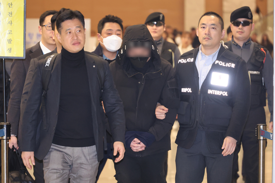 The 26 year-old, who is accused of masterminding a blackmail scheme using drinks mixed with drugs, entering the Incheon International Airport on Tuesday after being extradited from China. The person only identified as Lee has been in China since October 2022 while he was on trial for another extortion case. [YONHAP] 