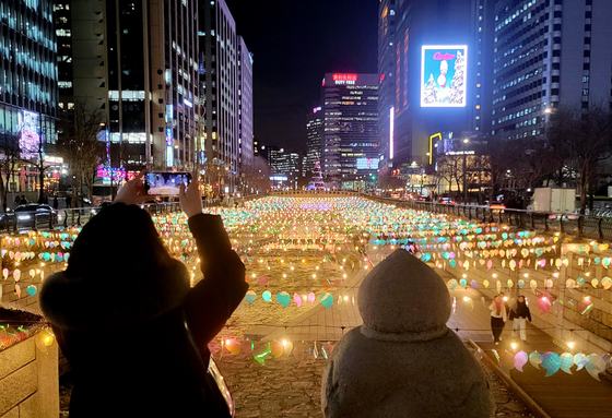 Visitors watch the lanterns lit up along Cheonggye Stream in downtown Seoul on Dec. 13. The lantern festival will be held as part of the capital's winter festival dubbed Seoul Winter Festa 2023 through Jan.21. [NEWS1] 