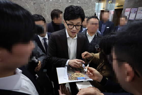 Former Justice Minister Han Dong-hoon signing autographs after visiting the Seongnam city office on Dec. 13. [YONHAP]