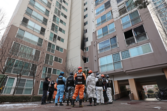 A team of police and firefighters investigate a fire that broke out on Monday Christmas morning at a high-rise apartment in Dobong District Seoul. The fire claimed the lives of two people while injuring nearly 30 people. [YONHAP] 