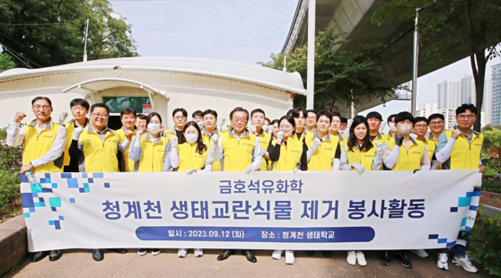Employees from Kumho Petrochemical headquarters participate in a clean-up volunteer activity at Cheonggyecheon to remove the invasive plants that disturb the stream’s ecosystem. [KUMHO PETROCHEMICAL]