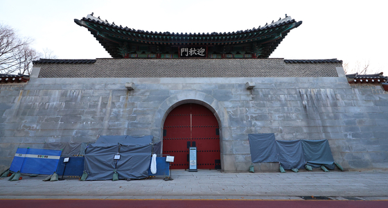 Graffiti sprayed on the walls of Yeongchumun Gate, the west entrance of Gyeongbok Palace in central Seoul, has been temporarily covered by officials on Saturday. [NEWS1]
