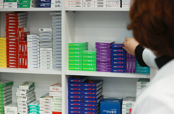 A pharmacist organizes antipyretics and antibiotics at a pharmacy in Seoul on Thursday. Amid soaring cases of influenza and other infectious respiratory diseases, related drugs are reported to be in short supply. [YONHAP]