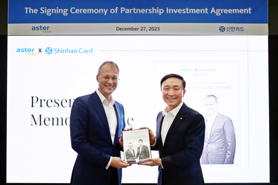Shinhan Card CEO Moon Dong-kwon, right, and Aster Group Chairman Alexey Bakal pose for a photo after signing a deal to establish a joint venture at Shinhan Card headquarters in central Seoul on Wednesday. [SHINHAN CARD]