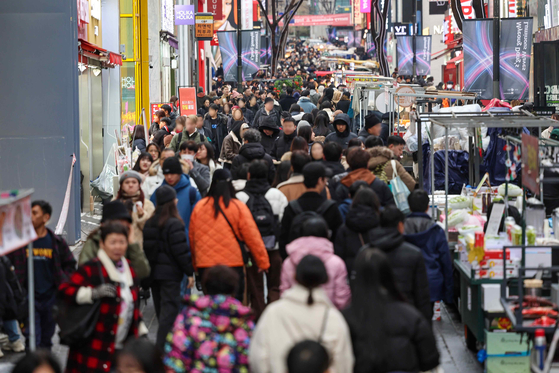 People throng a street in Myeong-dong, central Seoul, on New Year's Eve on Sunday. [YONHAP] 