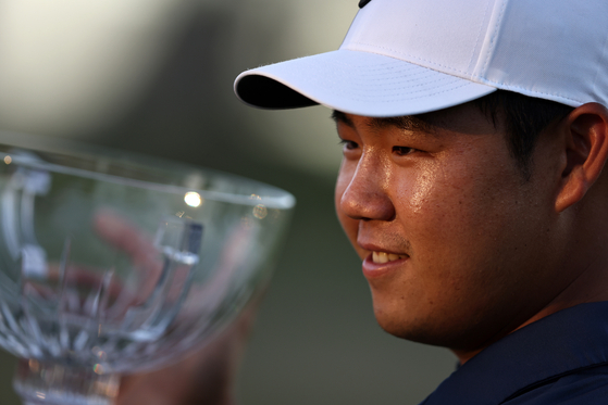 Tom Kim poses with the trophy after putting in to win on the 18th green during the final round of the Shriners Children's Open at TPC Summerlin in Las Vegas, Nevada on Oct. 15, 2023.  [GETTY IMAGES]