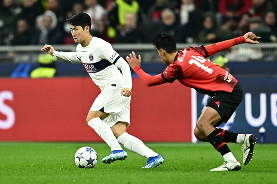 Paris Saint-Germain's Lee Kang-in, left, fights for the ball with AC Milan's Tijani Reijnders during a UEFA Champions League first round Group F match at San Siro Stadium in Milan on Nov. 7. [AFP/YONHAP]