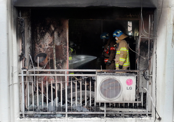 Firefighters check the burned unit of the apartment in Gunpo, Gyeonggi on Tuesday. [NEWS1]