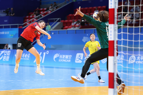 Korea's Yun Ye-jin, left, shoots during a handball final against Japan at the Hangzhou Asian Games held at Zhejiang Gongshang University Sports Centre in Hangzhou, China on Thursday. [NEWS1]