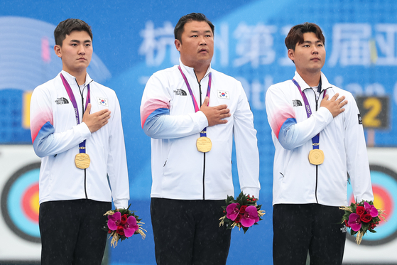 From left: Korea's Kim Je-deok, Oh Jin-hyek and Lee Woo-seok pose on the podium after taking gold in the men's team recurve archery event at the Hangzhou Asian Games in Hangzhou, China on Friday.  [NEWS1]