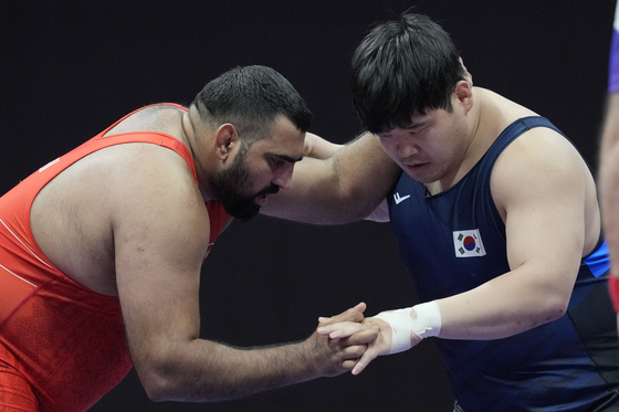 Korean wrestler Kim Min-seok, right, competes during the men's Greco-Roman 130-kilogram bronze medal bout at the Hangzhou Asian Games against Naveen of India at Lin’an Sports Culture & Exhibition Centre in Hangzhou, China on Thursday. [AP/YONHAP] 