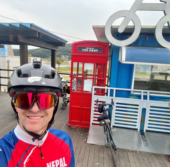 British Deputy Ambassador to Korea Gareth Weir in front of a red phone box to collect another stamp in his bike passport near Gumi, North Gyeongsang, during his cycling trip from Busan to Seoul from Oct. 6 to 9, 2023. [GARETH WEIR]