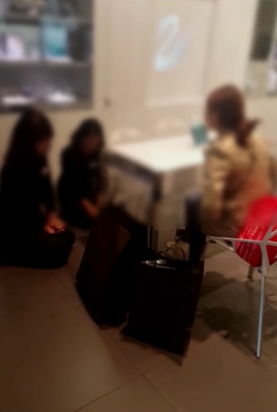 A female customer, unhappy with employees' responses to her request for free repairs, scolds two kneeling female employees at the Swarovski store in Shinsegae Department Store's Incheon Branch in 2015. [SCREEN CAPTURE]