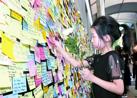 A child places a commemorative message at the memorial space in Seo2 Elementary School in southern Seoul on Sept. 4 following a death of a distressed young teacher due to parents' gapjil. [YONHAP]